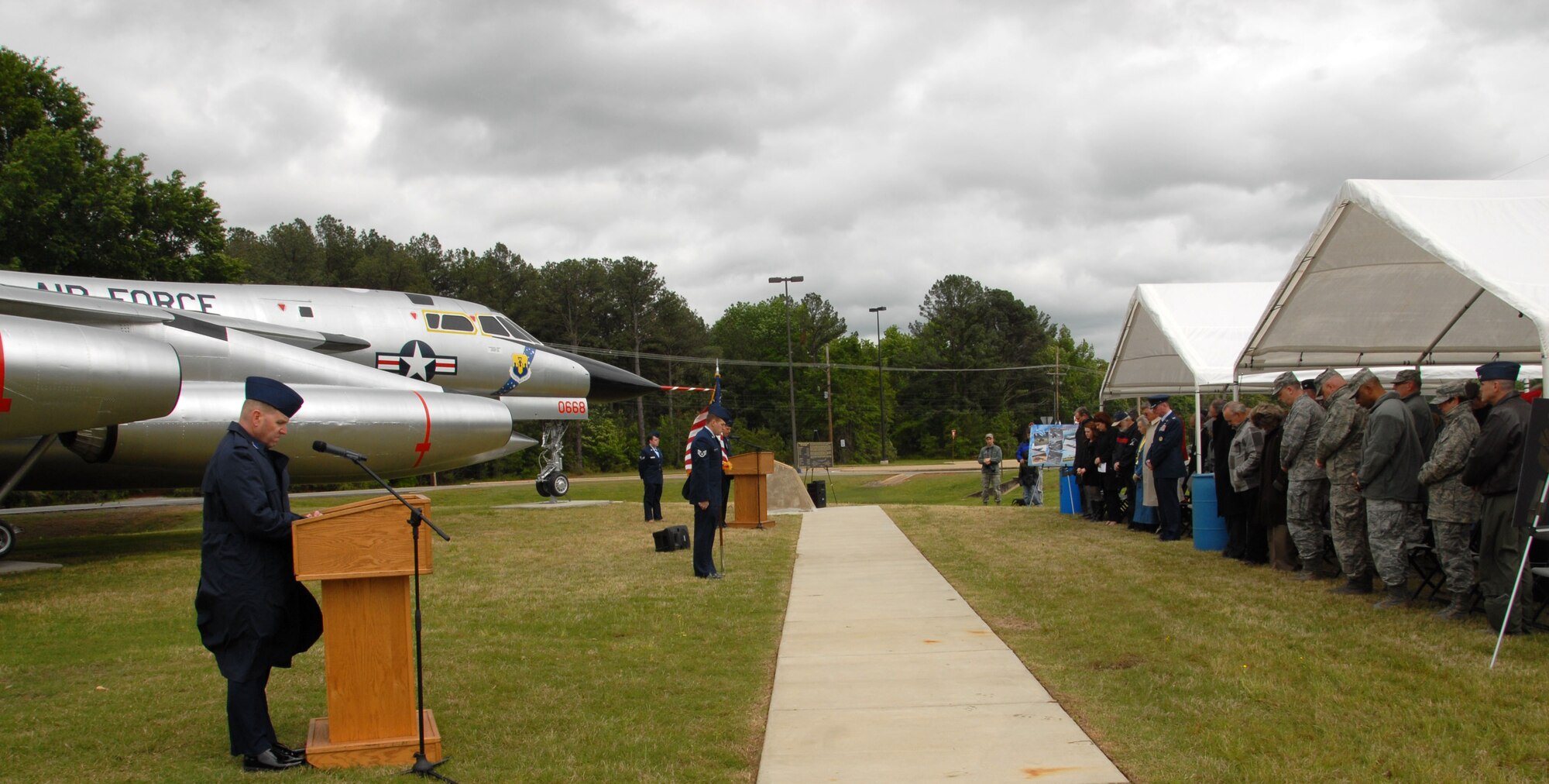Before the dedication of the B-58 Hustler members of Team Little Rock bow their heads during a moment of silence dedicated to the crews of the aircrafts lost supporting operations in Southwest Asia May 3, 2013, at Little Rock Air Force Base, Ark. The B-58 restoration project took 14 months for volunteers to complete. (U.S. Air Force photo by Senior Airman Regina Agoha)