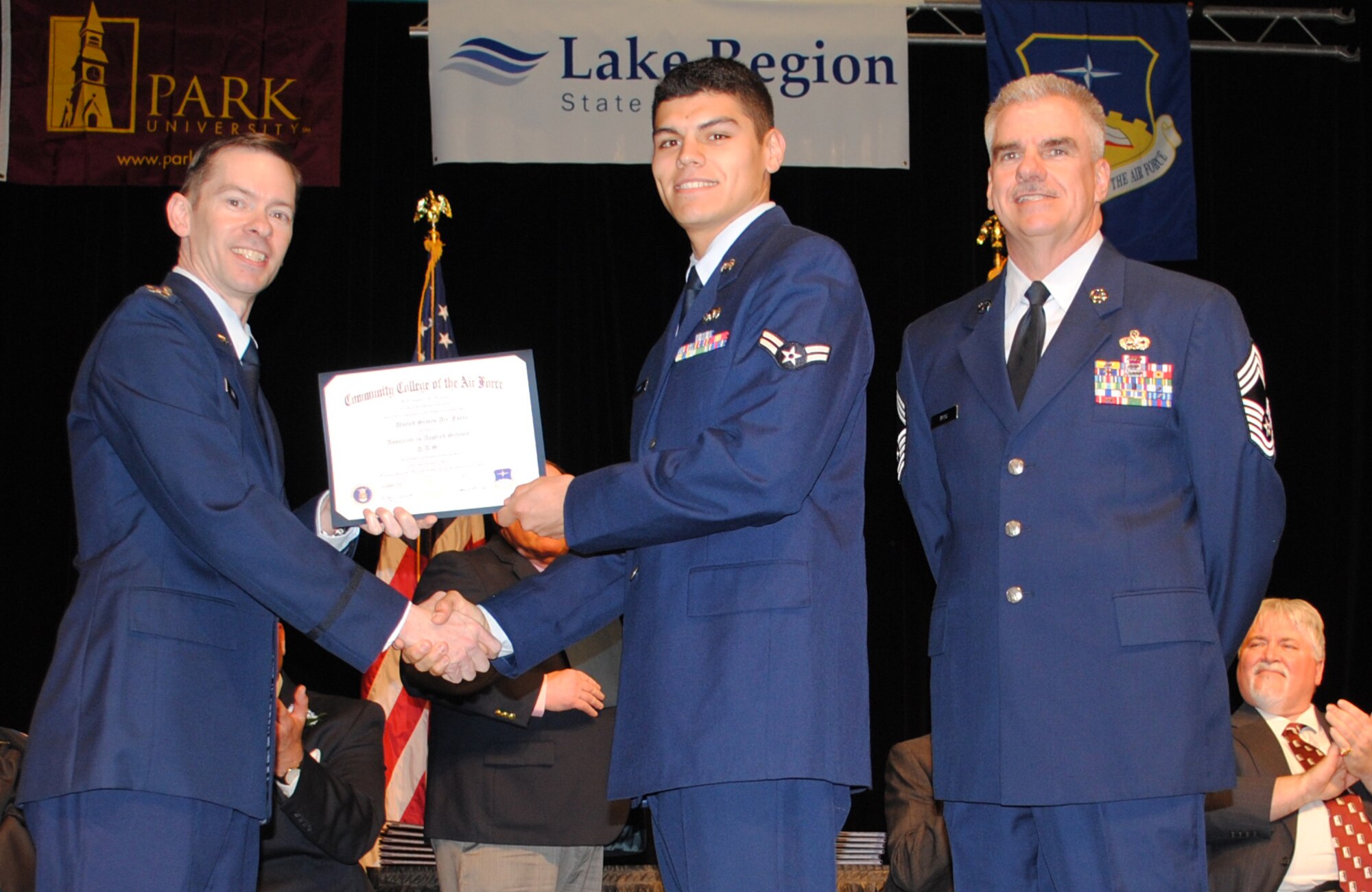 Airman 1st Class Kevin Ramos, 319th Logistics Readiness Squadron, poses for a photo with 319th Air Base Wing interim commander Col. Christopher Mann, left, and Chief Master Sgt. Timothy Byrd, 319th ABW command chief representative, after receiving his Community College of the Air Force associate’s degree during a combined school graduation ceremony held April 27, 2013 in East Grand Forks, Minn. Ramos returned just in time to pick up his diploma having recently returned from a deployment. (U.S. Air Force photo/Staff Sgt. Luis Loza Gutierrez)
