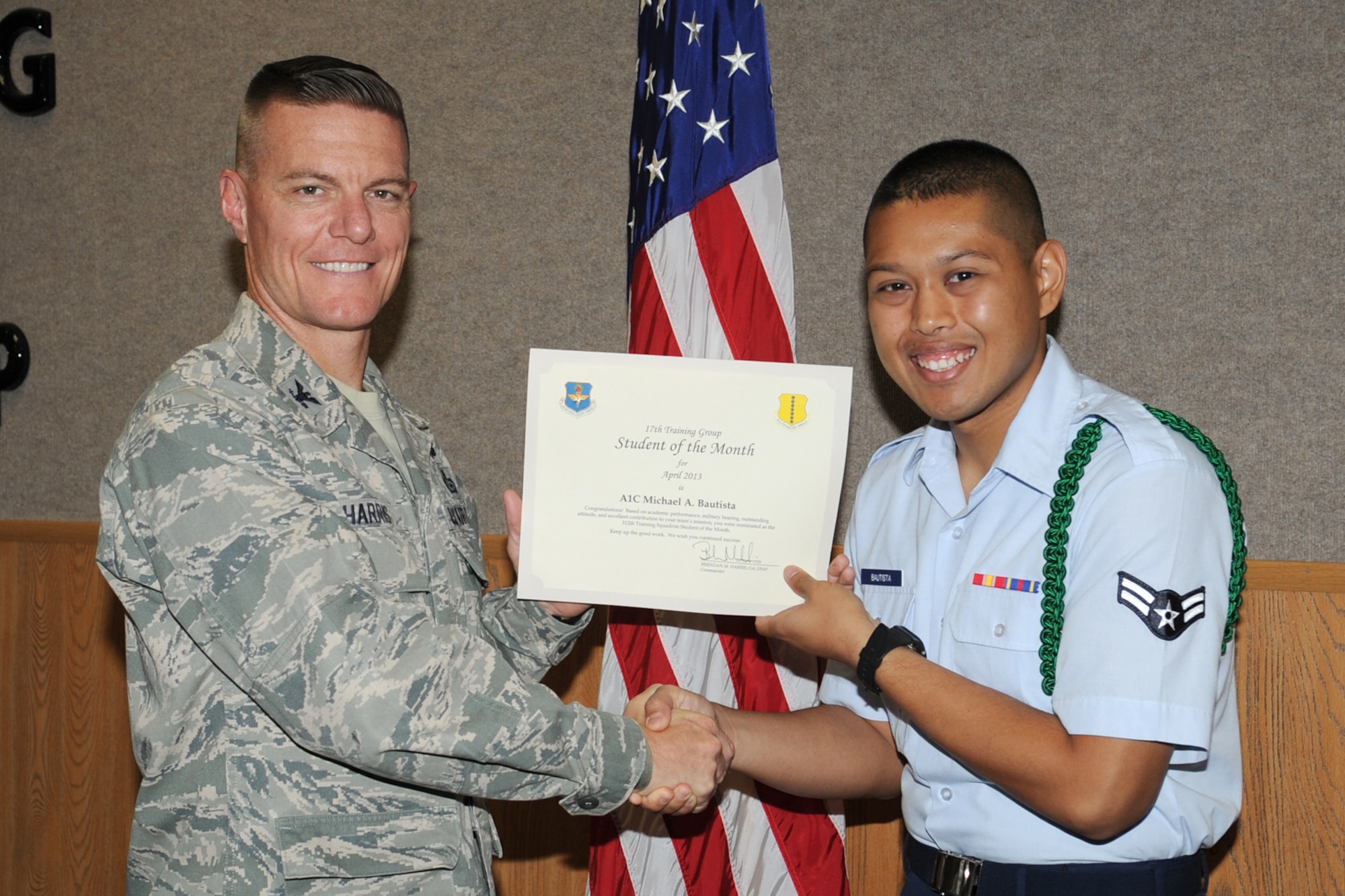 GOODFELLOW AIR FORCE BASE, Texas-- Col. Brendan Harris, 17th Training Group Commander, presents Airman 1st Class Michael Bautista with the 312th Training Squadron Student of the Month award for April, May 3. (U.S. Air Force photo/Staff Sgt. Laura R. McFarlane)