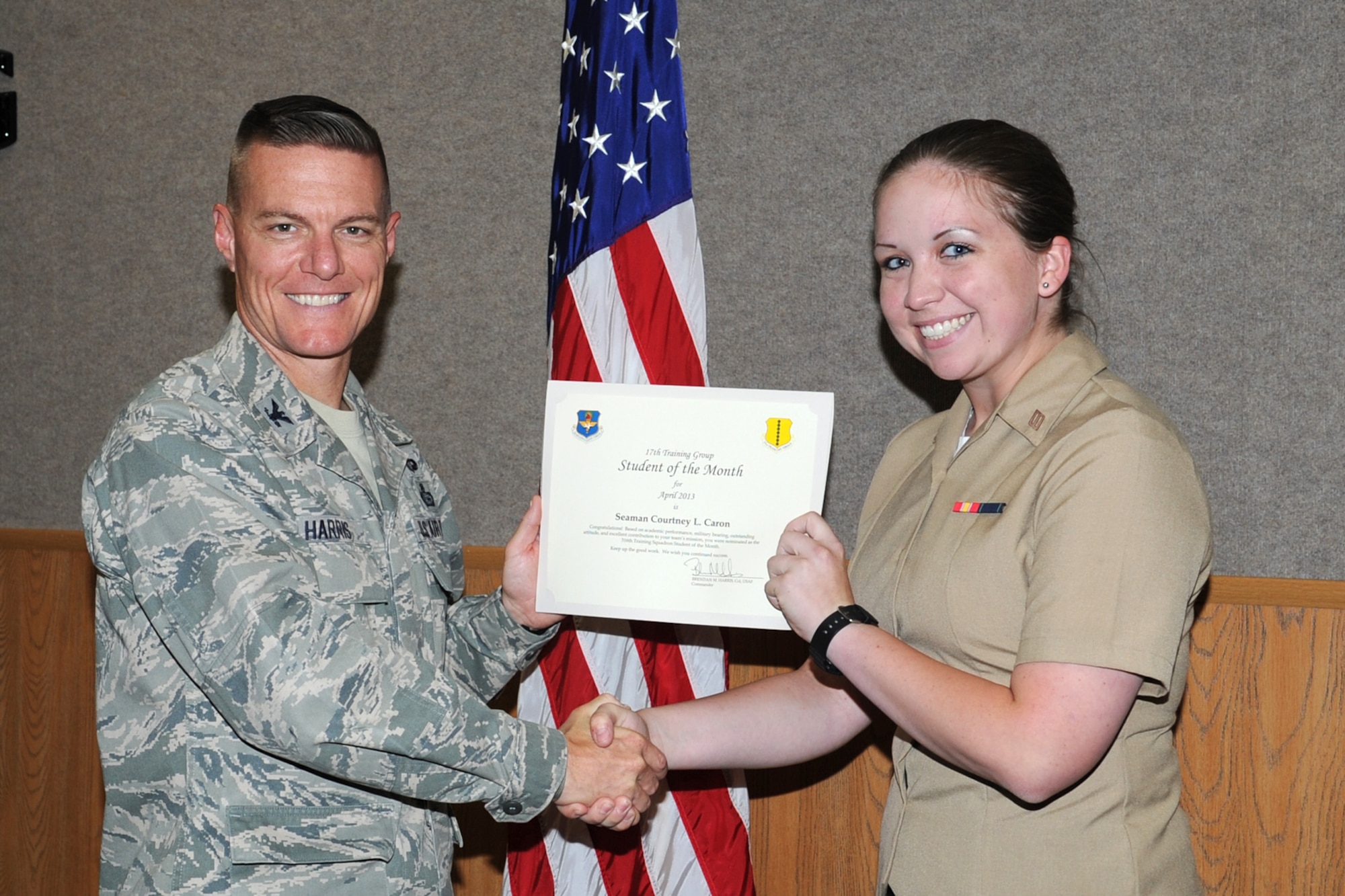 GOODFELLOW AIR FORCE BASE, Texas-- Col. Brendan Harris, 17th Training Group Commander, presents Navy Seaman Courtney Caron with the 316th Training Squadron Student of the Month award for April, May 3. (U.S. Air Force photo/Staff Sgt. Laura R. McFarlane)
