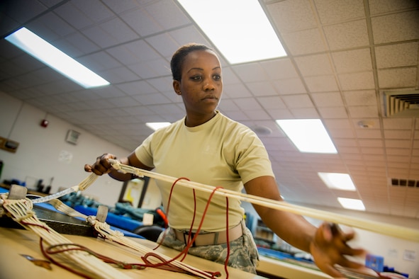 U.S. Air Force Senior Airman Arlena Newson, 23d Operations Support Squadron aircrew flight equipment journeyman, inspects a parachute April 9, 2013, at Moody Air Force Base, Ga. As an AFE journeyman, her job is to ensure flight equipment is in perfect working order, ranging from parachute and harness inspections to making sure survival kits are serviceable. (U.S. Air Force photo by Staff Sgt. Jamal D. Sutter/Released)