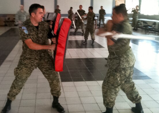 Two soldiers of the Salvadoran Army practice striking with the extendable baton as members of the 157 Security Forces Squadron look on. San Salvador, El Salvador, March 13 2013. (U.S. Air National Guard photo courtesy MSgt. Dale Snowdon) 