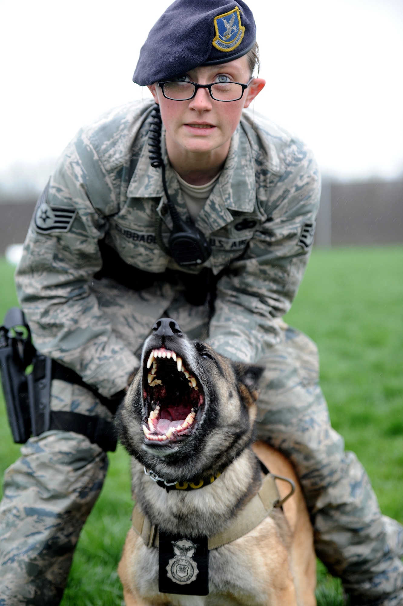Staff Sgt. Amanda Cubbage, 509th Security Forces Squadron canine handler, holds back her canine, Mina, during a controlled aggression exercise at Whiteman Air Force Base, March 23, 2013. The exercise teaches canines to follow commands and helps strengthen the bond between dogs and their handlers. (U.S. Air Force photo by Staff Sgt. Nick Wilson/Released)