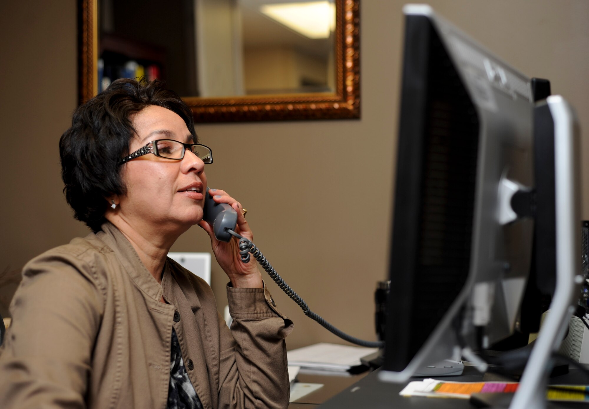 Nelda Barrientes, 28th Medical Group secretary, answers the phone at her desk inside the 28th MDG at Ellsworth Air Force Base, S.D., May 3, 2013. Barrientes daily tasks consist of coordinating staff schedules, reviewing and editing important documents and most significantly assisting the group commander. (U.S. Air Force photo by Airman 1st Class Anania Tekurio/Released)