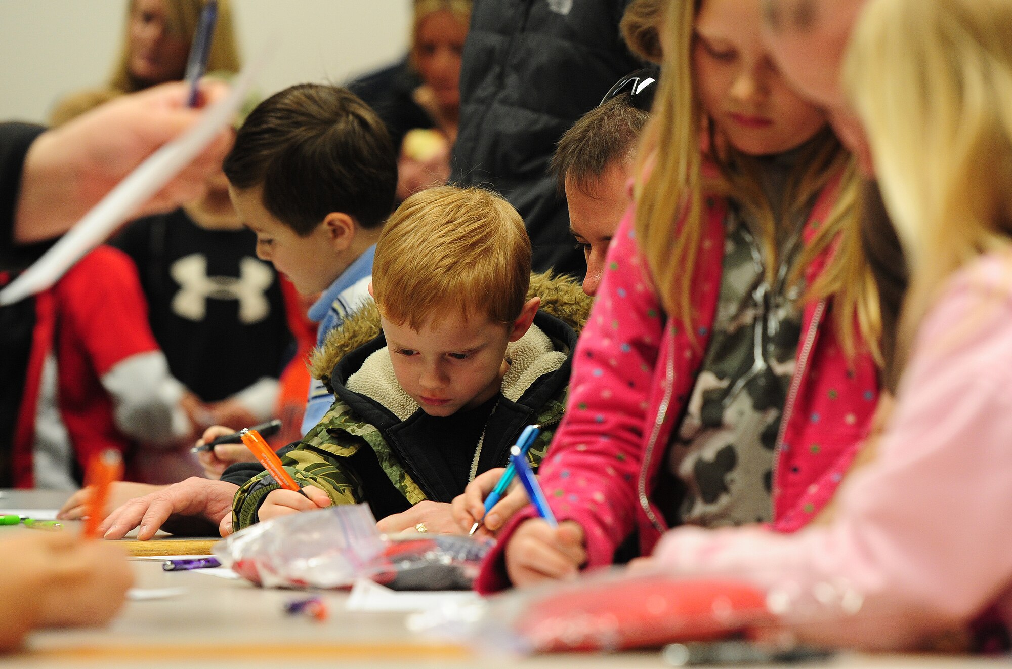 Children fill out paperwork in a simulated personnel deployment function during Operation Spirit at Whiteman Air Force Base, Mo., April 20, 2013. Operation Spirit is held annually to help children experience a “deployment” in a way they understand. (U.S. Air Force photo by Staff Sgt. Nick Wilson/Released)