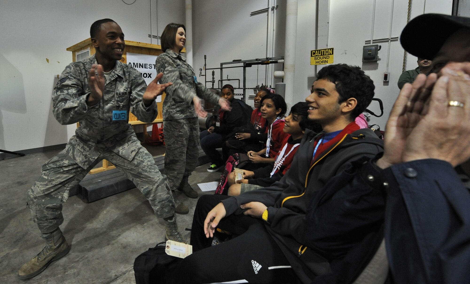 Senior Airman Joel Flowers, 509th Maintenance Squadron, and Staff Sgt. Stacey Evanitus, 509th Logistics Readiness Squadron, motivate children and parents of their assigned mock deployment chalks to yell out their chalk chant during Operation Spirit at Whiteman Air Force Base, Mo., April 20, 2013. Operation Spirit is hosted once a year to show military children a piece of what their parents might experience through a deployment. (U.S. Air Force photo by Staff Sgt. Nick Wilson/Released)