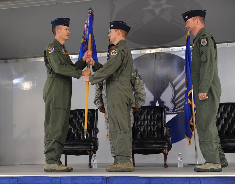 U.S. Air Force Col. Billy Thompson, 23 Wing commander, hands over the guidon to Col. Derek Oaks, incoming 23d Fighter Group commander, during a change of command ceremony at Moody Air Force Base, Ga., May 3, 2013. Receiving the guidon from Thompson represented Oaks assuming command of the unit. (U.S. Air Force photo by Airman Alexis Grotz/Released) 