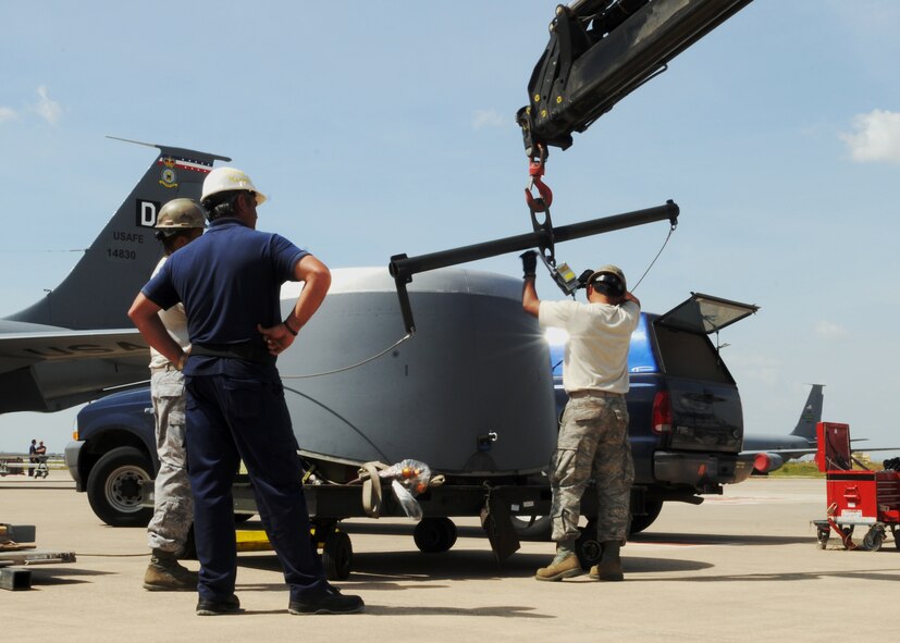 Flightline maintainers and a contractor use a crane to lift the engine ring cowl onto the No. 4 engine of a KC-135R Stratotanker April 22, 2013. The cowl was removed to allow deployed 100th Air Refueling Wing maintainers to swap a damaged engine out with a replacement. (U.S. Air Force photo by 1st Lt. Christopher Mesnard/Released)