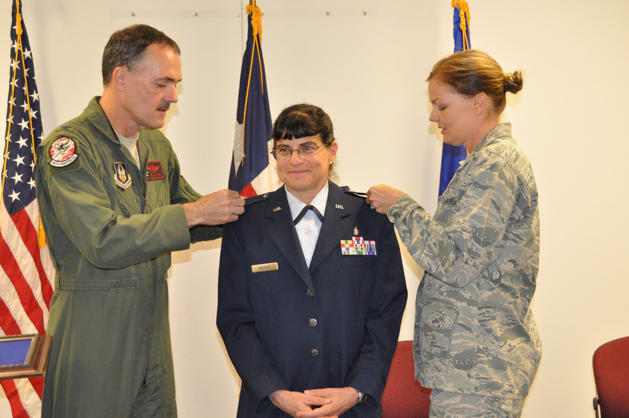 Major Holly Brewer, 301st Nutritional Medicine Flight officer in charge, is promoted to the rank of lieutenant colonel in a joint-promotion ceremony Monday, May 6 at Naval Air Station Fort Worth Joint Reserve Base, Texas. Colonel Bill Lyons, 301st Fighter Wing vice commander, and Capt. Melissa Davis, 301st NMF Dietician, pinned on the new rank for Brewer. During the ceremony, Brewer was recognized for her dedication and hard work. (U.S. Air Force photo by Senior Airman Melissa Harvey/released)
