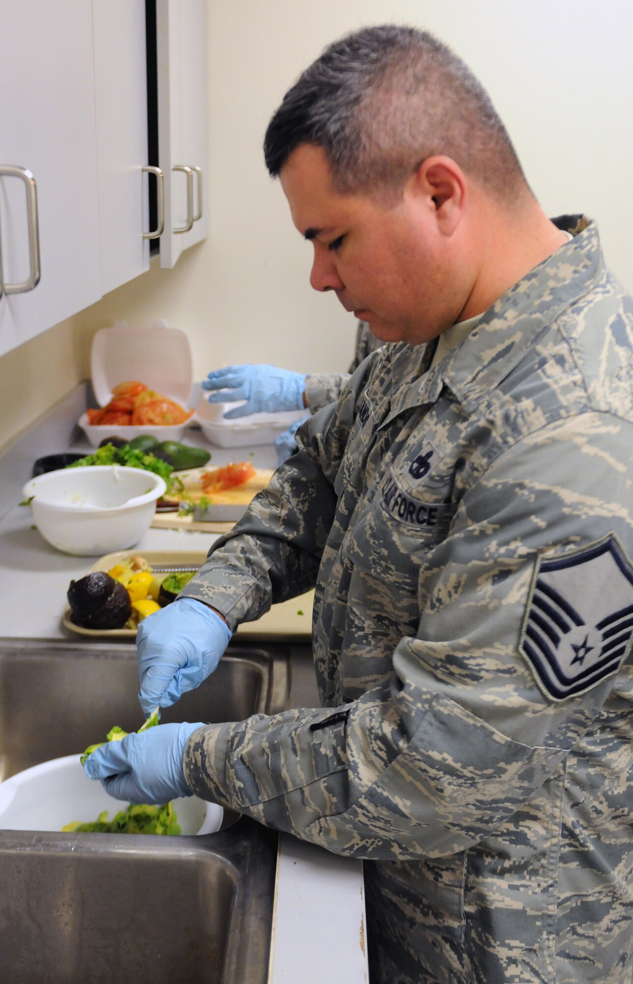 Master Sgt. Jordi Sancho, Air Forces Central transportation manager, prepares avocados, the main ingredient in guacamole, May 3 at an undisclosed location in Southwest Asia. (U.S. Air Force photo by Staff Sgt. Rachelle Elsea)