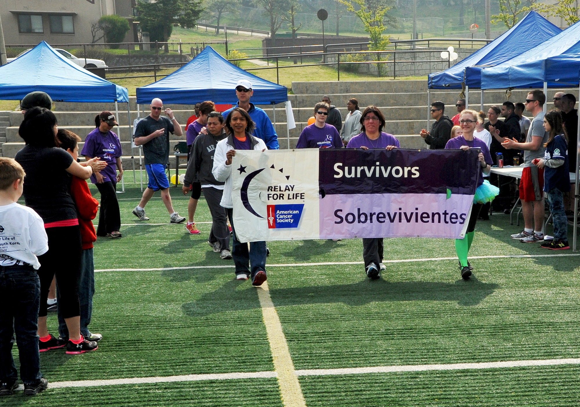 Chaplain (Capt.) Rachel David, 51st Fighter Wing chaplain, right, Nina Chandeck and Staff Sgt. Gloria Kuzmicki, 51st Mission Support Group knowledge operator, leads the first lap of the 2013 Relay for Life walk at Osan Air Base, Republic of Korea, May 4-5, 2013. The first lap is designated for survivors to celebrate their victory over cancer. (U.S. Air Force photo/Senior Airman Kristina Overton)