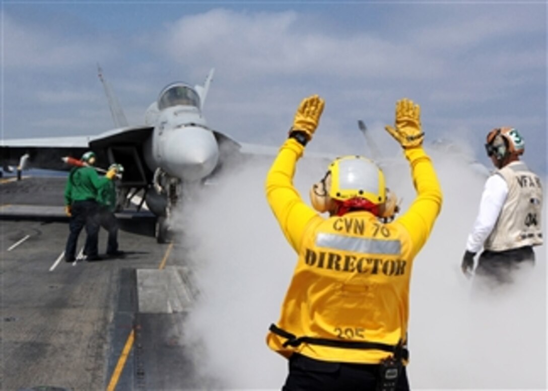 Navy Petty Officer 3rd Class Angela Crabtree directs the pilot of an F/A-18E Hornet to the steam catapult on the aircraft carrier USS Ronald Reagan (CVN 76) as the ship conducts flight operations in the Pacific Ocean on May 4, 2013.  Reagan is underway to conduct flight deck certifications and carrier qualifications. 