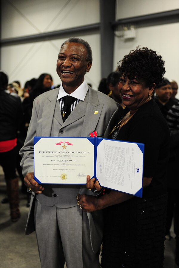 Former Pfc. Robert L. Rimpson holds up his award citation during an awards ceremony at the 24th Marine Regiment Drill Hall where he was presented the Bronze Star Medal with Combat "V" device, May 4.