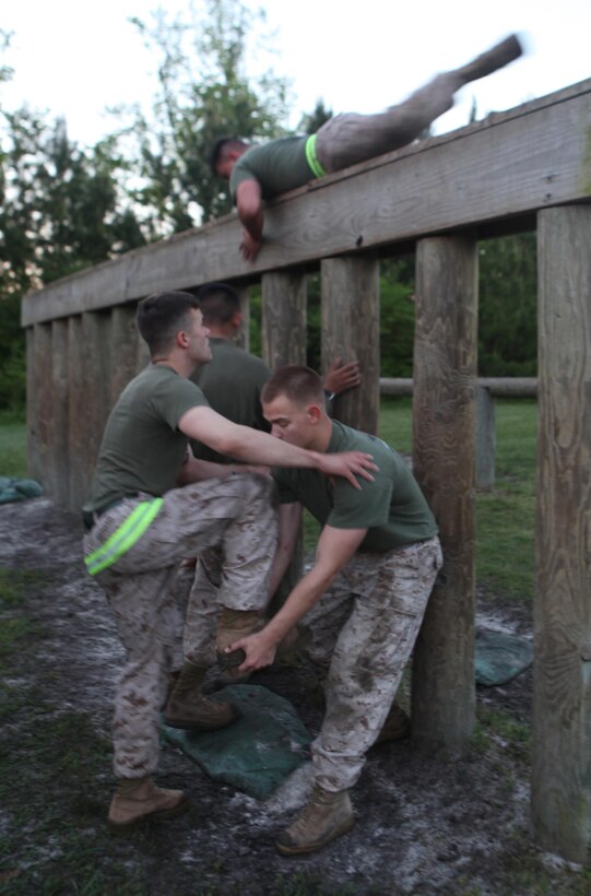 A Marine with 2nd Maintenance Battalion, Combat Logistics Regiment 25, 2nd Marine Logistics Group gives a team member a leg up in the obstacle course during a battalion physical training competition aboard Camp Lejeune, N.C., April 26, 2013. The battalion was split into squads during the timed competition and the Marines and sailors had to complete each exercise with their teams to build camaraderie while challenging them to work together. 
