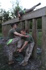 A Marine with 2nd Maintenance Battalion, Combat Logistics Regiment 25, 2nd Marine Logistics Group gives a team member a leg up in the obstacle course during a battalion physical training competition aboard Camp Lejeune, N.C., April 26, 2013. The battalion was split into squads during the timed competition and the Marines and sailors had to complete each exercise with their teams to build camaraderie while challenging them to work together. 