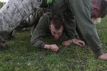 A Marine with 2nd Maintenance Battalion, Combat Logistics Regiment 25, 2nd Marine Logistics Group crawls under a line of Marines during a battalion physical training competition aboard Camp Lejeune, N.C., April 26, 2013. The battalion performed different squad-based activities, including “building a house”, an exercise in which one servicemember crawls between the arms and legs of others.  