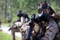 Marines with 2nd Maintenance Battalion, 2nd Marine Logistics Group provide security as other members of the 13 manned squad apply their mission oriented protective posture gear at a training exercise during the super squad challenge aboard Camp Lejeune, N.C., May 3, 2013. Troops were tested in a simulated chemical weapons attack by how fast they can get into MOPP 4, which is the highest level of protection from gas threats.