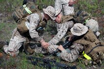 Marines with 2nd Maintenance Battalion, 2nd Marine Logistics Group use combat life saver skills and apply a tourniquet to the simulated victim during a super squad challenge aboard Camp Lejeune, N.C., May 3, 2013. Servicemembers with the battalion had to use first-aid on victims and treat their wounds after a simulated booby trap deployed. 