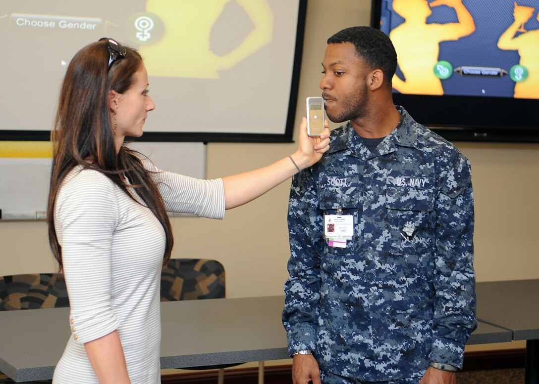 Ms. Mindy Martini performs an alcohol breath-testing check on Seaman Terrance Scott during an intoxiclock® presentation during the hospital’s Alcohol Awareness Fair April 29.  Martini is from the Marine Corps Community Services Camp Pendleton Consolidated Substance Abuse Counseling Center and Scott is a logistical specialist from the Naval Hospital Camp Pendleton Material Management Department. The fair, held in conjunction with Alcohol Awareness Month, had representatives from the hospital and MCB Camp Pendleton. (U.S. Navy photo by Mass Communication Specialist 1st Class Michael R. McCormick)
