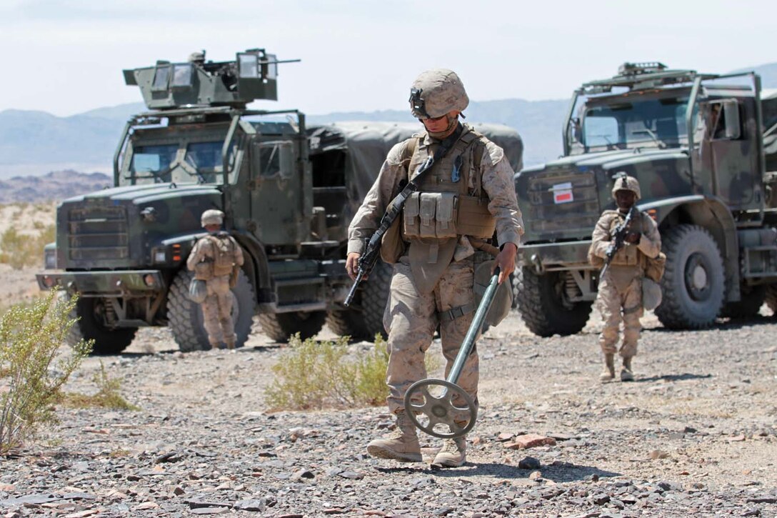 Lance Cpl. Dakota A. Fillers, a motor transport operator with Truck Company Alpha, Headquarters Battalion, 1st Marine Division, simulates using a metal detector to sweep the ground for simulated improvised explosive devices here, May 3, 2013. Fillers, a 19-year-old native of Greenville, Tenn., cleared a route for the rest of the convoy to arrive and recover the disabled vehicle and Marines. (U.S. Marine Corps photo by Sgt. Jacob H. Harrer)