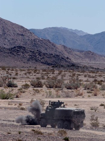 A simulated improvised explosive device erupts in front of a seven-ton truck here, May 3, 2013. During the exercise, Truck Company Alpha, Headquarters Battalion, 1st Marine Division, conducted convoy training while also supporting 1st Marine Division with transportation. (U.S. Marine Corps photo by Sgt. Jacob H. Harrer)