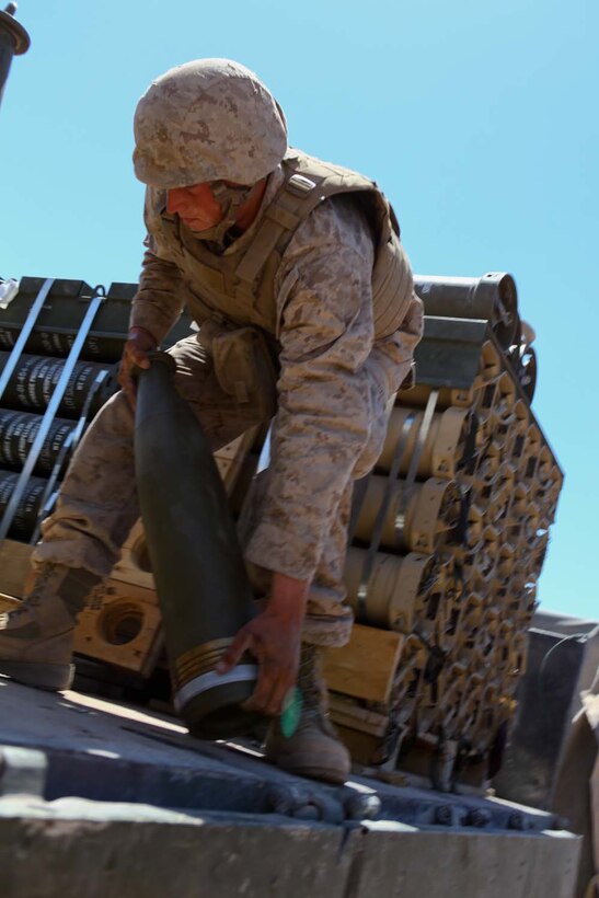 Private First Class Brandon Emery, an ammunition truck driver serving with Kilo Battery, 3rd Battalion, 12th Marine Regiment, attached to 2nd Battalion, 11th Marines, loads a high-explosive round onto the back of a seven-ton truck during Exercise Desert Scimitar here, May 3, 2013. This is the first time in more than a decade the Marine Corps conducted the exercise.