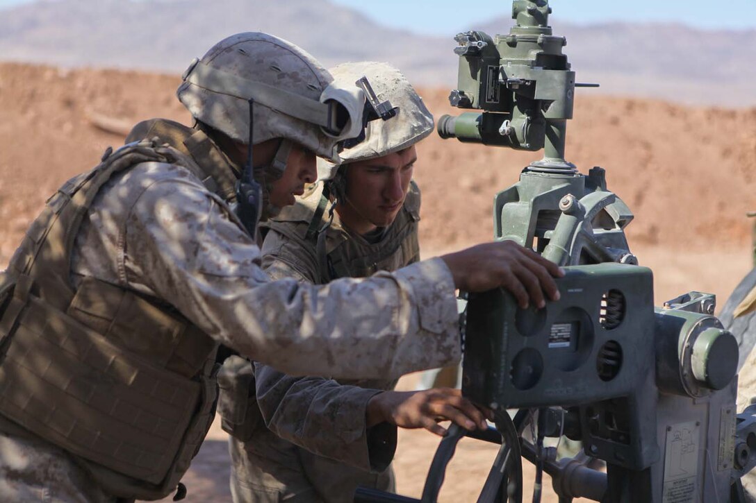 Corporal Edwin Aguinaldo Jr., a section chief serving with Kilo Battery, 3rd Battalion, 12th Marine Regiment, attached to 2nd Battalion, 11th Marines, and Cpl. John Hoskins, Aguinaldo's assistant section chief, make adjustments to an M777 Lightweight Howitzer during Exercise Desert Scimitar, a live-fire training exercise, here, May 2, 2013. Aguinaldo, a native of Kapolie, Hawaii, and Hoskins, a native of Fort Walton Beach, Fla., worked with several Marines to fire the weapon. The exercise focused on the training and preparation of 1st Marine Division as the ground combat element of a Marine Air-Ground Task Force.