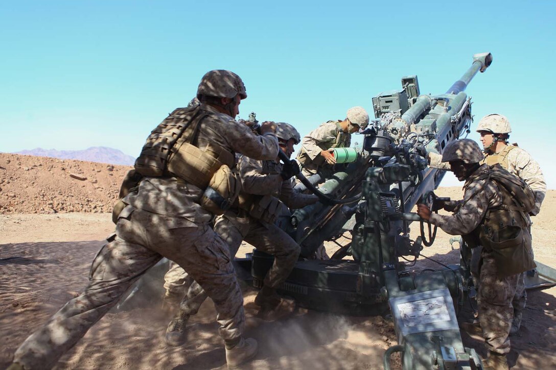 Marines serving with Kilo Battery, 3rd Battalion, 12th Marine Regiment, attached to 2nd Battalion, 11th Marines, load a high explosive round into an M777 Lightweight Howitzer during exercise Desert Scimitar here, May 2, 2013. During the Exercise, Marines participated in 24-hour operations, launching high explosive and illumination rounds.