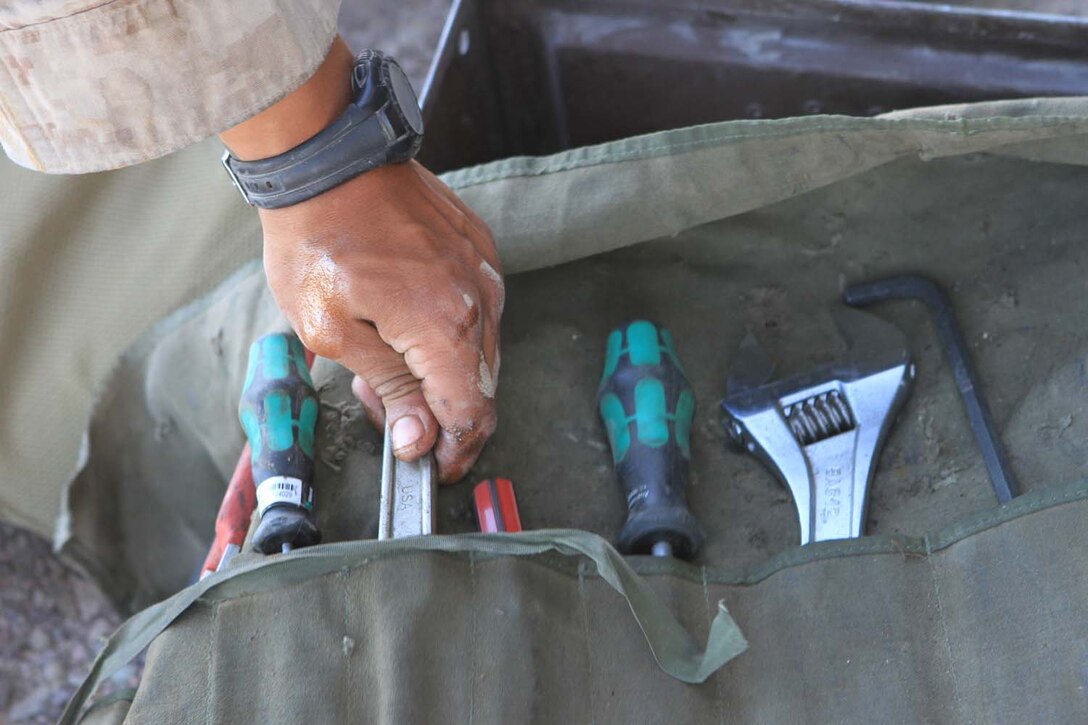 Corporal Diego Castaneda, a motor transportation maintenance chief serving with Golf Battery, 2nd Battalion, 11th Marine Regiment, grabs a wrench from his tool kit before working on a 7-ton truck during Exercise Desert Scimitar, a combined-arms, live-fire training exercise here, May 3, 2013. Castaneda, a native of Gibbon, Neb., is the only mechanic in the battery and is in charge of keeping more than 40 vehicles properly maintained and running. Captain William Turner, the commanding officer of Golf Battery, said thanks to Castaneda's devotion and hard work, the battery is one of the few in 11th Marines that can commute to and from the Combat Center without vehicles breaking down.