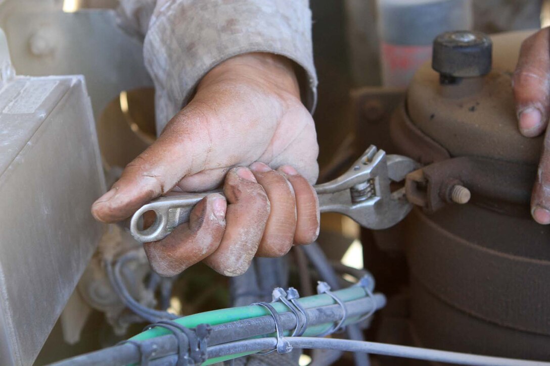 Corporal Diego Castaneda, a motor transportation maintenance chief serving with Golf Battery, 2nd Battalion, 11th Marine Regiment, tightens a screw on the power steering reservoir during Exercise Desert Scimitar, a combined-arms, live-fire training exercise here, May 3, 2013. Castaneda, a native of Gibbon, Neb., is the only mechanic in the battery and is in charge of keeping more than 40 vehicles properly maintained and running. Captain William Turner, the commanding officer of Golf Battery, said thanks to Castaneda's devotion and hard work, the battery is one of the few in 11th Marines that can commute to and from the Combat Center without vehicles breaking down.