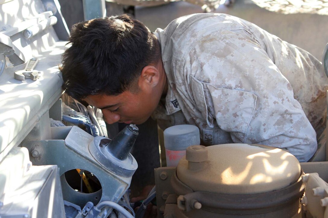 Corporal Diego Castaneda, a motor transportation maintenance chief serving with Golf Battery, 2nd Battalion, 11th Marine Regiment, inspects the engine of a 7-ton truck during Exercise Desert Scimitar, a combined-arms, live-fire training exercise here, May 3, 2013. Castaneda, a native of Gibbon, Neb., is the only mechanic in the battery and is in charge of keeping more than 40 vehicles properly maintained and running. Captain William Turner, the commanding officer of Golf Battery, said thanks to Castaneda's devotion and hard work, the battery is one of the few in 11th Marines that can commute to and from the Combat Center without vehicles breaking down.