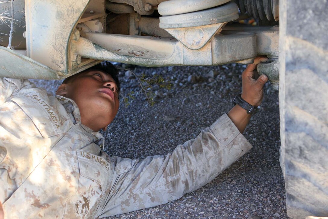 Corporal Diego Castaneda, a motor transportation maintenance chief serving with Golf Battery, 2nd Battalion, 11th Marine Regiment, inspects the underside of a 7-ton truck during Exercise Desert Scimitar, a combined-arms, live-fire training exercise here, May 3, 2013. Castaneda, a native of Gibbon, Neb., is the only mechanic in the battery and is in charge of keeping more than 40 vehicles properly maintained and running. Captain William Turner, the commanding officer of Golf Battery, said thanks to Castaneda's devotion and hard work, the battery is one of the few in 11th Marines that can commute to and from the Combat Center without vehicles breaking down.