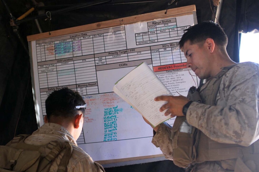 Second Lt. Pascual Eley (right), a fire directions officer serving with 2nd Battalion, 11th Marine Regiment, and a native of Fullerton, Calif., and Sgt. Christopher Martinez, the operations chief with the fire direction center and a native of Orange County, Calif., convert target data into firing commands for the gunline during Exercise Desert Scimitar, a combined-arms, live-fire training exercise here, May 2, 2013. The FDC's job is to take the information given to them by forward observers and compute how wind, air pressure, temperature, humidity and other weather conditions will effect an artillery round while airborne.
