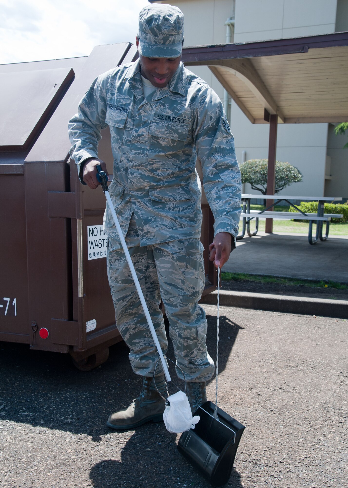 YOKOTA AIR BASE, Japan – Airman 1st Class Keith Richberg-Brown with the 374th Logistics Readiness Squadron picks up garbage at Yokota Air Base, Japan, May 2, 2013.  Simple act of picking up and throwing away trash helps immensely in maintaining common areas.  (U.S. Air Force photo by Airman 1st Class Soo C. Kim)