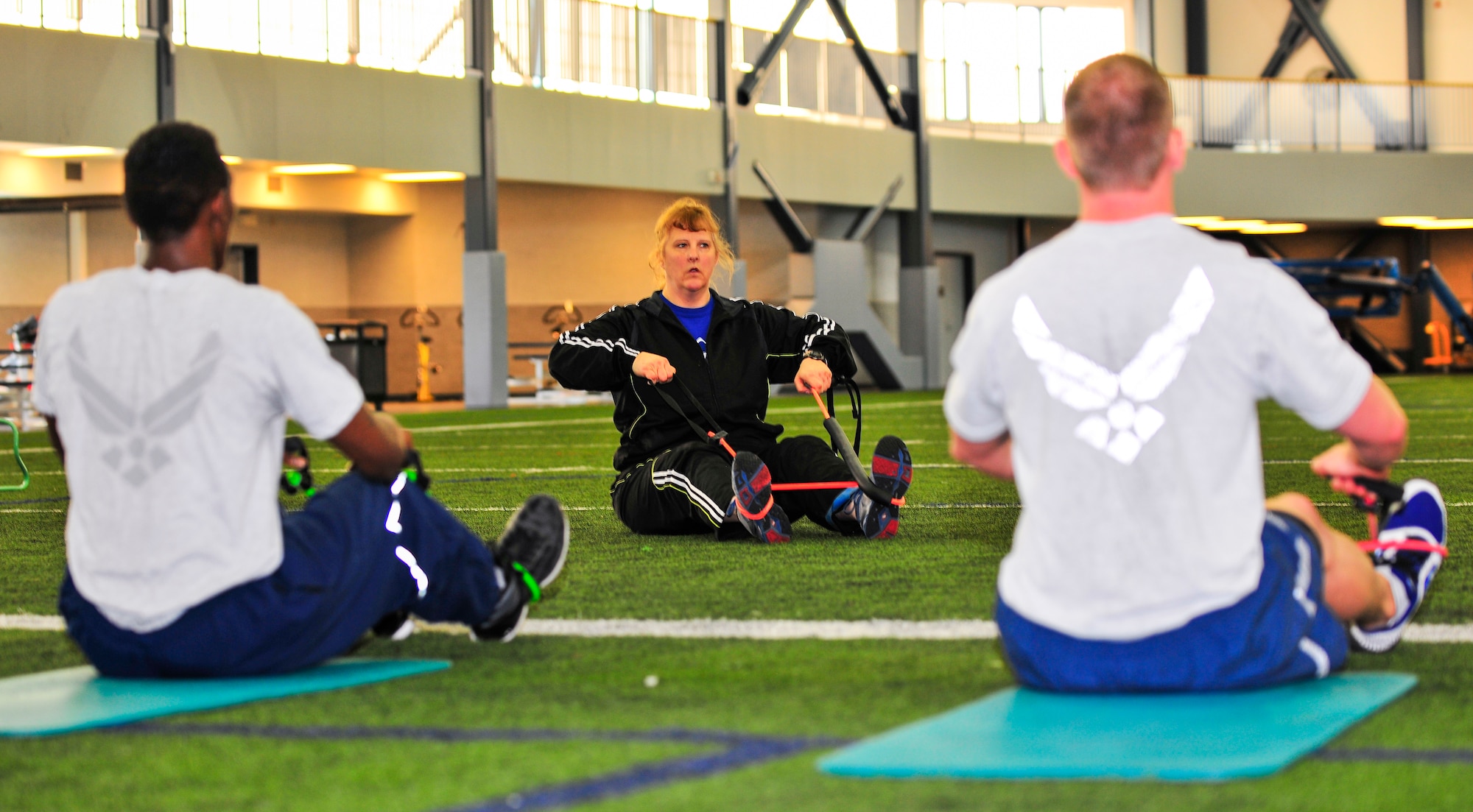 Dana Baugh, 354th Medical Operations Squadron exercise physiologist, demonstrates proper stretching form during a physical training leader class at the fitness center May 7, 2013, Eielson Air Force Base, Alaska. Health and Wellness Center members are dedicated to disease prevention and management and health education to support healthy lifestyles. (U.S. Air Force photo by Racheal E. Watson/Released)