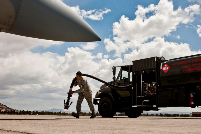 Airman 1st Class Jonathan Gutierrez, 99th Logistics Readiness Squadron fuels distribution operator, carries a fueling hose away from a Kovatch-International R-11 refueler to service an F-15C Eagle May 7, 2013, at Nellis Air Force Base, Nev. Operators make multiple trips to the flightline daily to ensure that aircraft have the fuel required to carry out the mission. (U.S. Air Force photo by Airman 1st Class Joshua Kleinholz) 