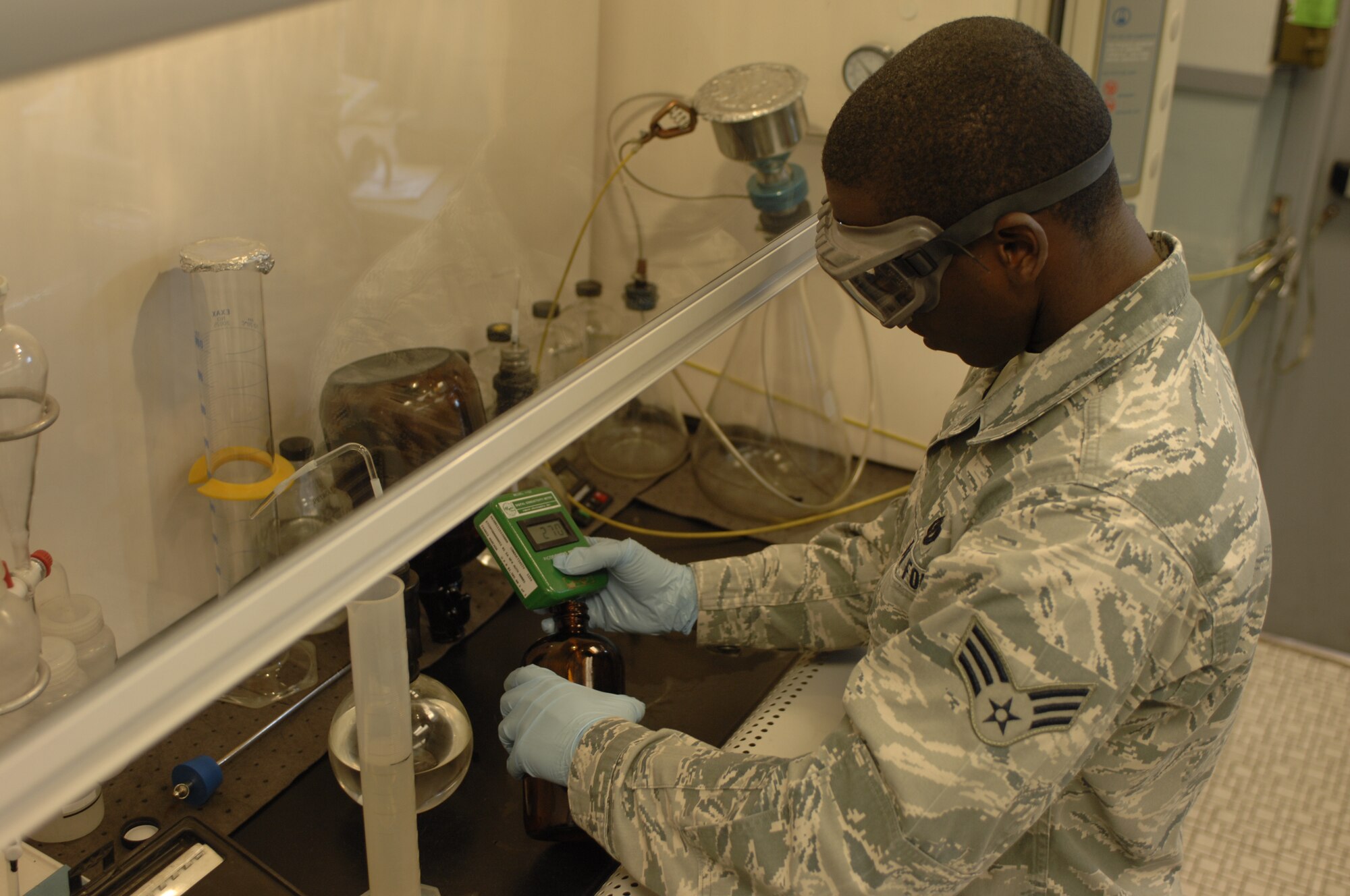 Senior Airman Courtney T. Lewis, 99th Logistics Readiness Squadron fuels lab technician, tests a fuel sample for sediment May 2, 2013, at Nellis Air Force Base, Nev. Lab technicians test fuel samples periodically to make sure Nellis aircraft are powered by only the highest quality fuels. (U.S. Air Force photo by Airman 1st Class Joshua Kleinholz)