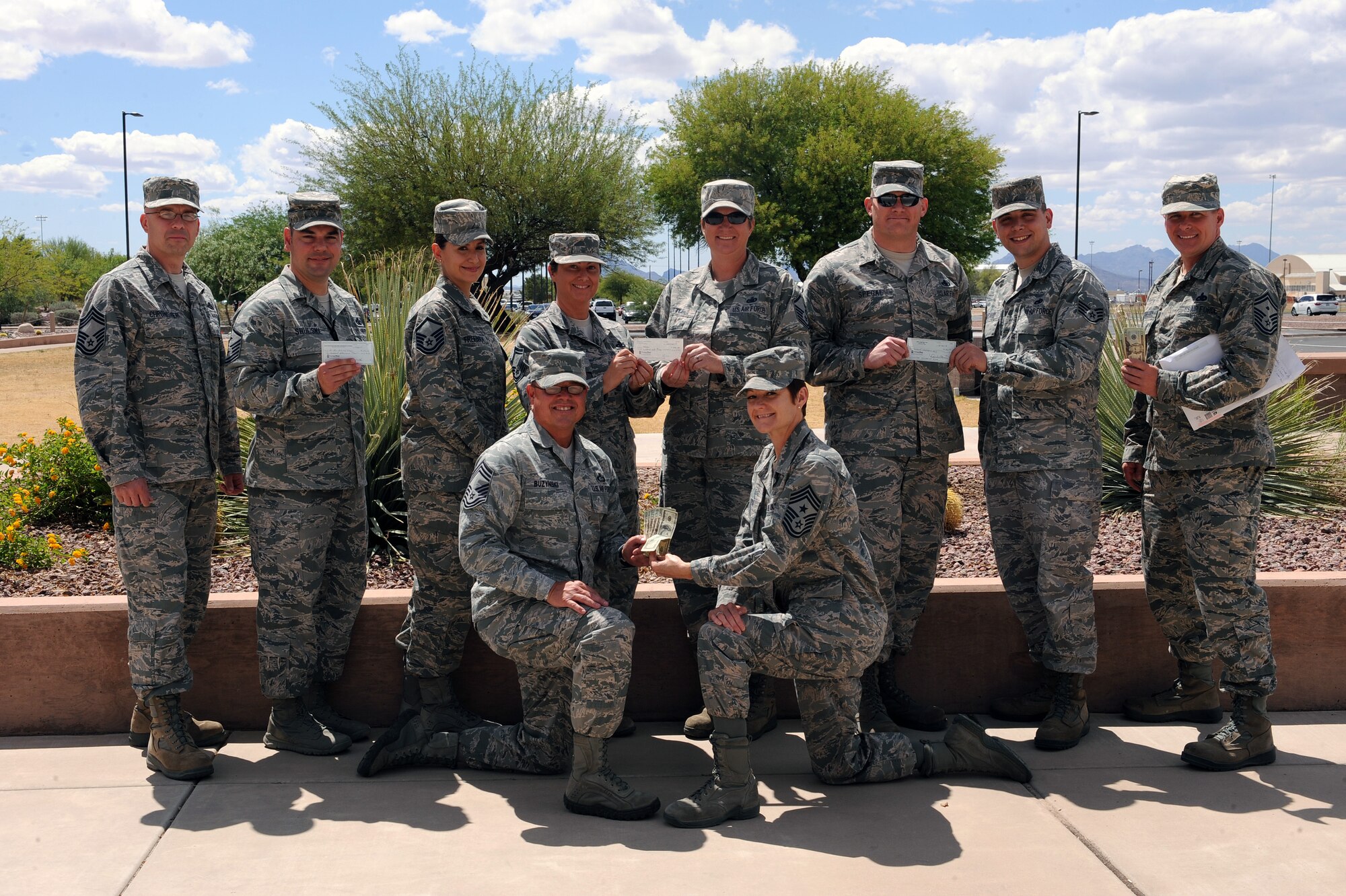 U.S. Air Force Airmen representatives from the First Sergeants’ Council,  Air Force Sergeants Association, Top Three, First Six, and Chiefs Group pose with donated money for the Air Force Enlisted Village at Davis-Monthan Air Force Base, Ariz., May 6, 2013. Each Professional Organization donated $200 which resulted in raising $1000 toward a Bronze Sponsorship at the 10th Annual AFEV Bob Hope Memorial Charity Golf Classic held at Eglin AFB, Fla. (U.S. Air Force photo by Airman 1st Class Christine Griffiths/Released)