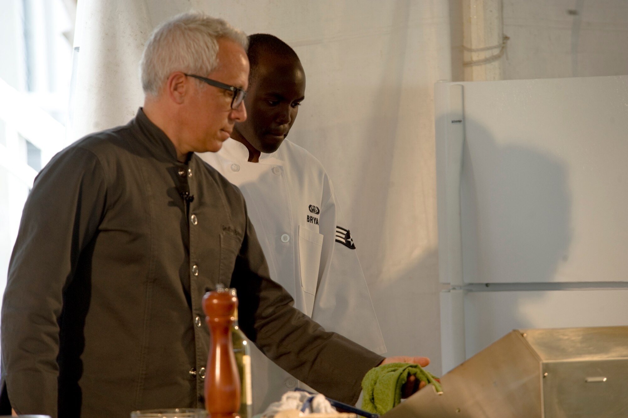 Geoffrey Zakarian, chef and restaurateur, and Senior Airman Broderick Bryan, food service specialist with 1st Special Operations Force Support Squadron, make a final check on their cooking progress during a cooking demonstration at the Navarre Beach Chamber of Commerce’s Taste of Navarre Seafood in the Navarre Park at Navarre, Fla., April 28.  Bryan assisted Zakarian in preparation and the cooking demonstration itself.  (U.S. Air Force Photo by Airman 1st Class Benjamin Kim)