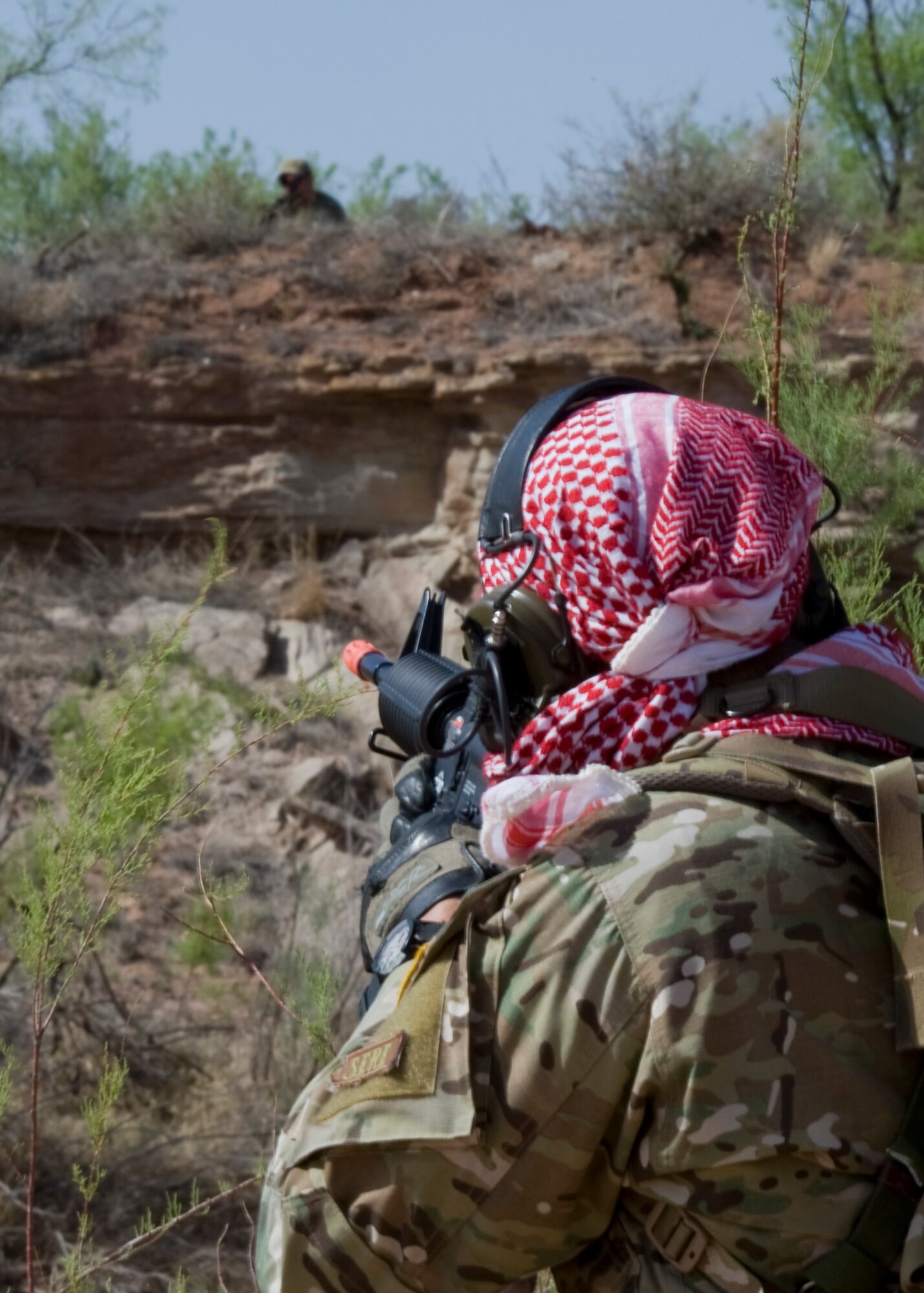 U.S. Air Force Staff Sgt. Leonard Clark, 317th Operations Support Squadron, Dyess Air Force Base, Texas, aims a simulated weapon at a U.S. Air Force Joint Terminal Attack Controller (JTAC) from Fort Sill, Okla., while acting as an enemy insurgent during a joint training exercise May 1, 2013, near Snyder, Texas. During the exercise, JTACs directed Dyess B-1 Bombers to provide close air support on simulated high-value targets during several realistic scenarios. (U.S. Air Force photo by Airman 1st Class Peter Thompson/Released)