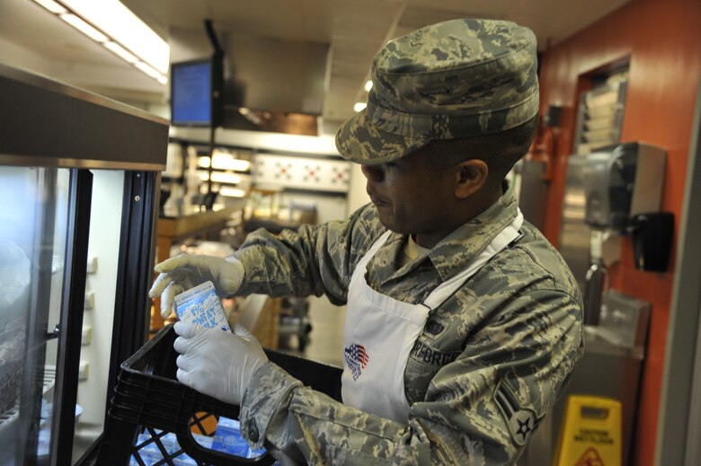 Airman 1st Class Jairzinho Chin, 509th Force Support Squadron services apprentice, restocks milk at the Ozark Inn on Whiteman Air Force Base, Mo. April 15, 2013. Airmen must replenish food supply to ensure customers have a variety of selections. (U.S. Air Force photo by Airman 1st Class Keenan Berry/Released)	