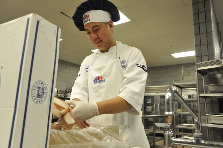 Airman Eric Sadsad, 509th Support Squadron services apprentice, removes bacon from a box at the Ozark Inn on Whiteman Air Force Base, Mo. April 15, 2013. Sadsad and other food services staff members prepare food to keep incoming shift workers on schedule (U.S. Air Force photo by Airman 1st Class Keenan Berry/Released)