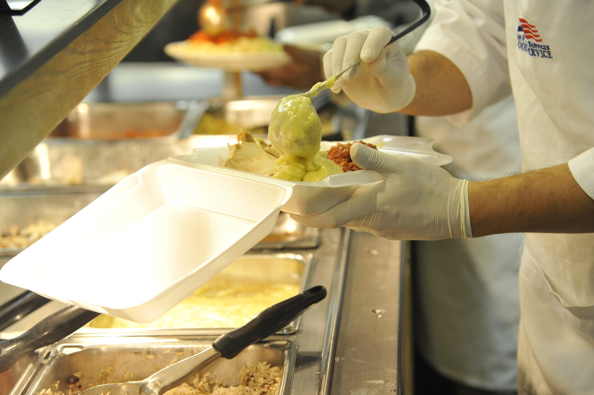 Airman Eric Sadsad, 509th Support Squadron services apprentice, puts food in a carry-out box in the Ozark Inn dining facility at Whiteman Air Force Base, Mo. April 15, 2013. To ensure Whiteman personnel receive sustenance throughout the entire meal period, the Ozark Inn focuses on portion control. (U.S. Air Force photo by Airman 1st Class Keenan Berry/Released)