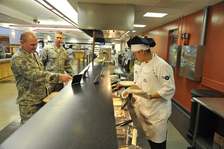 Airman Eric Sadsad, 509th Support Squadron services apprentice, serves food to a customer at the Ozark Inn on Whiteman Air Force Base, Mo. April 15, 2013. The dining facility takes pride in delivering outstanding customer service and maintaining professionalism. (U.S. Air Force photo by Airman 1st Class Keenan Berry/Released)