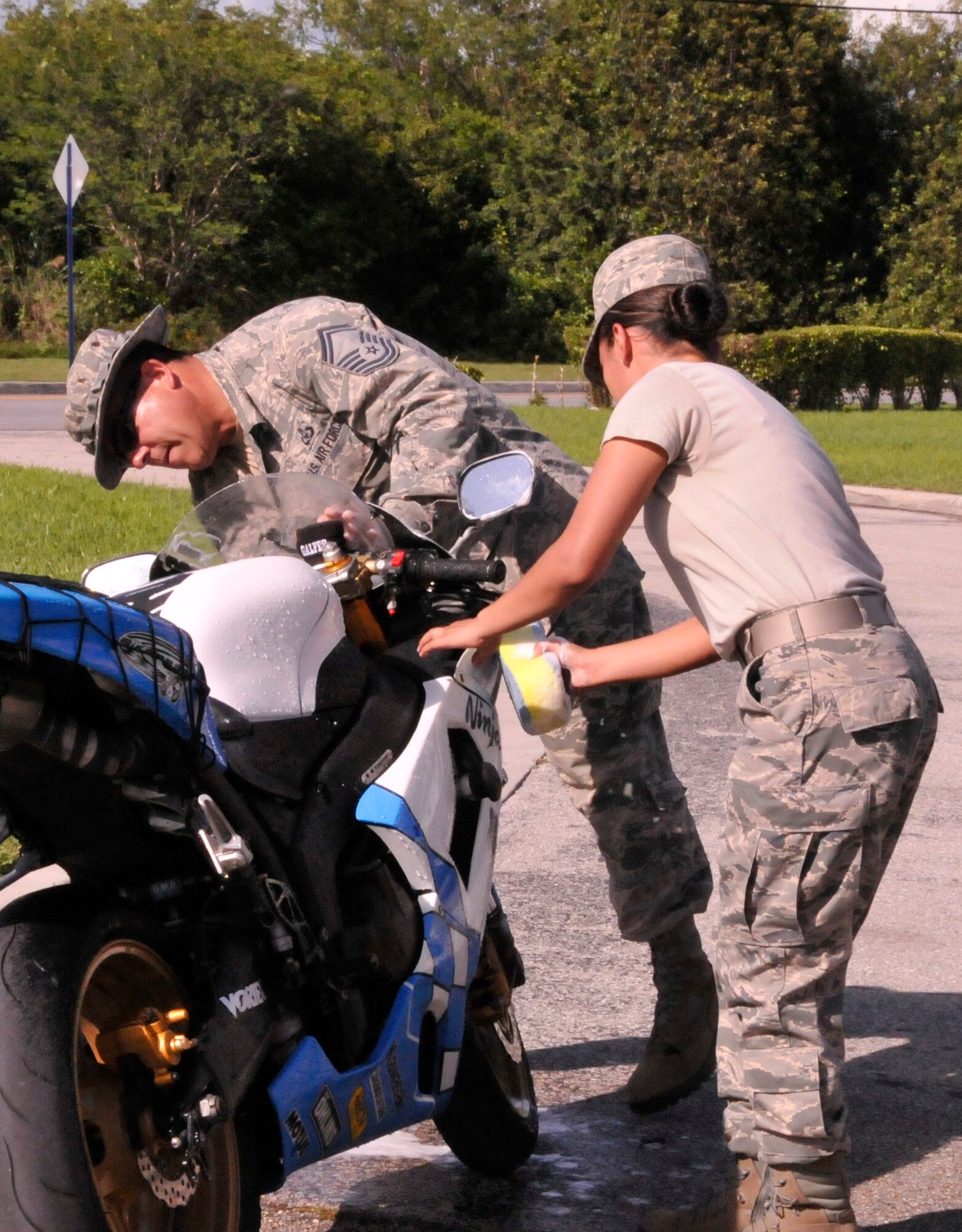 Senior Master Sgt. Tony Romero and Senior Airman Marcela Scalia soap up a motorcycle during a car wash here May 4. The funds raised during the car wash went toward the base's Airman's Council. (U.S. Air Force photo/Senior Airman Jaimi Upthegrove)