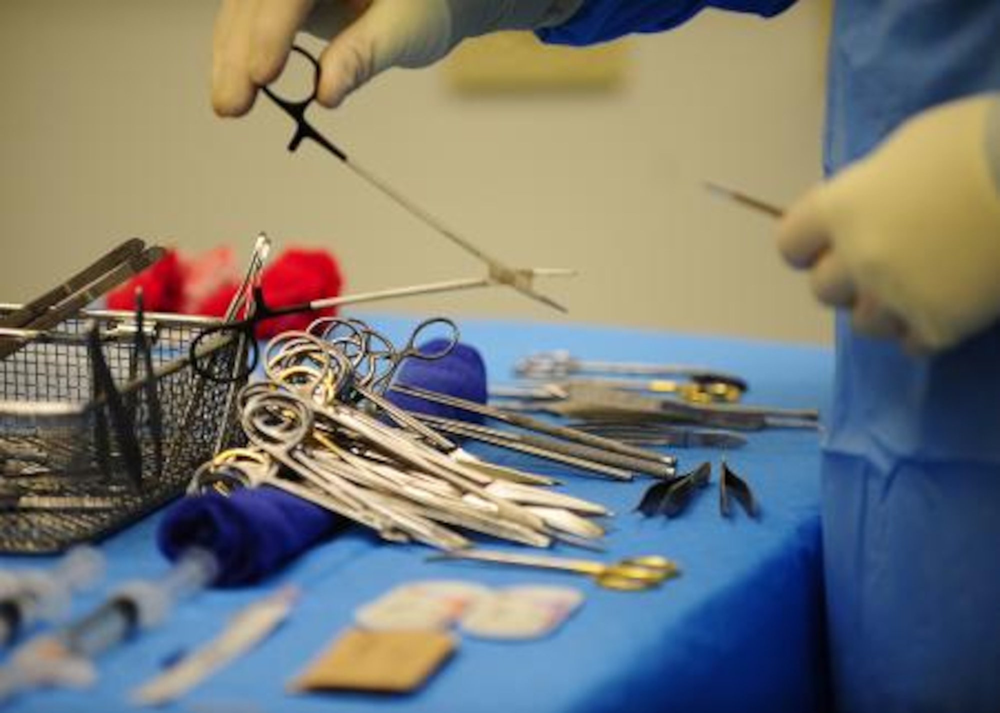 U.S. Air Force Tech. Sgt. Andrew Casey, operating room technician from Wilford Hall Medical Center, Texas, picks up a surgical tool while a syndactyly surgery is performed during a surgery medical readiness training exercise at Northern Regional Hospital in Orange Walk, Belize, May 2, 2013. Syndactyly is a condition where the digits of the hand or foot are fused or webbed together. Military medical professionals from the U.S. are providing free medical treatment at multiple medical readiness training exercises throughout Belize as part of an exercise known as New Horizons. The MEDRETES are designed to provide humanitarian assistance and medical care to people in several communities, while helping improve the skills of U.S. military medical forces. (U.S. Air Force photo by Tech Sgt. Tony Tolley/Released)