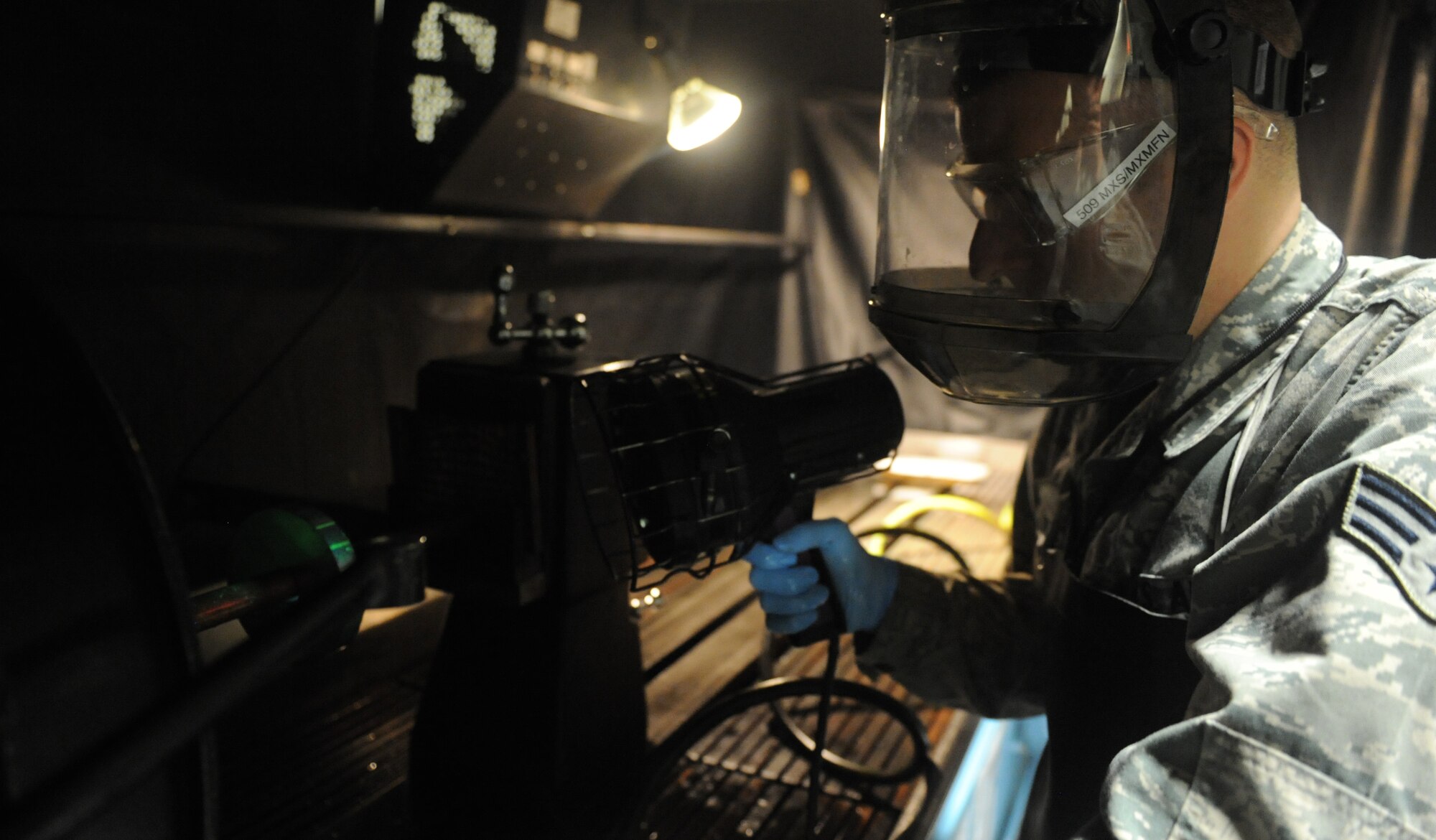 Senior Airman Joel Flowers, 509th Maintenance Squadron non-destructive inspection journeyman, uses a black light to inspect an aircraft part at Whiteman Air Force Base, Mo., May 1, 2013. The black light causes particles normally unseen by the human eye to become florescent. (U.S. Air Force photo by Airman 1st Class Bryan Crane)