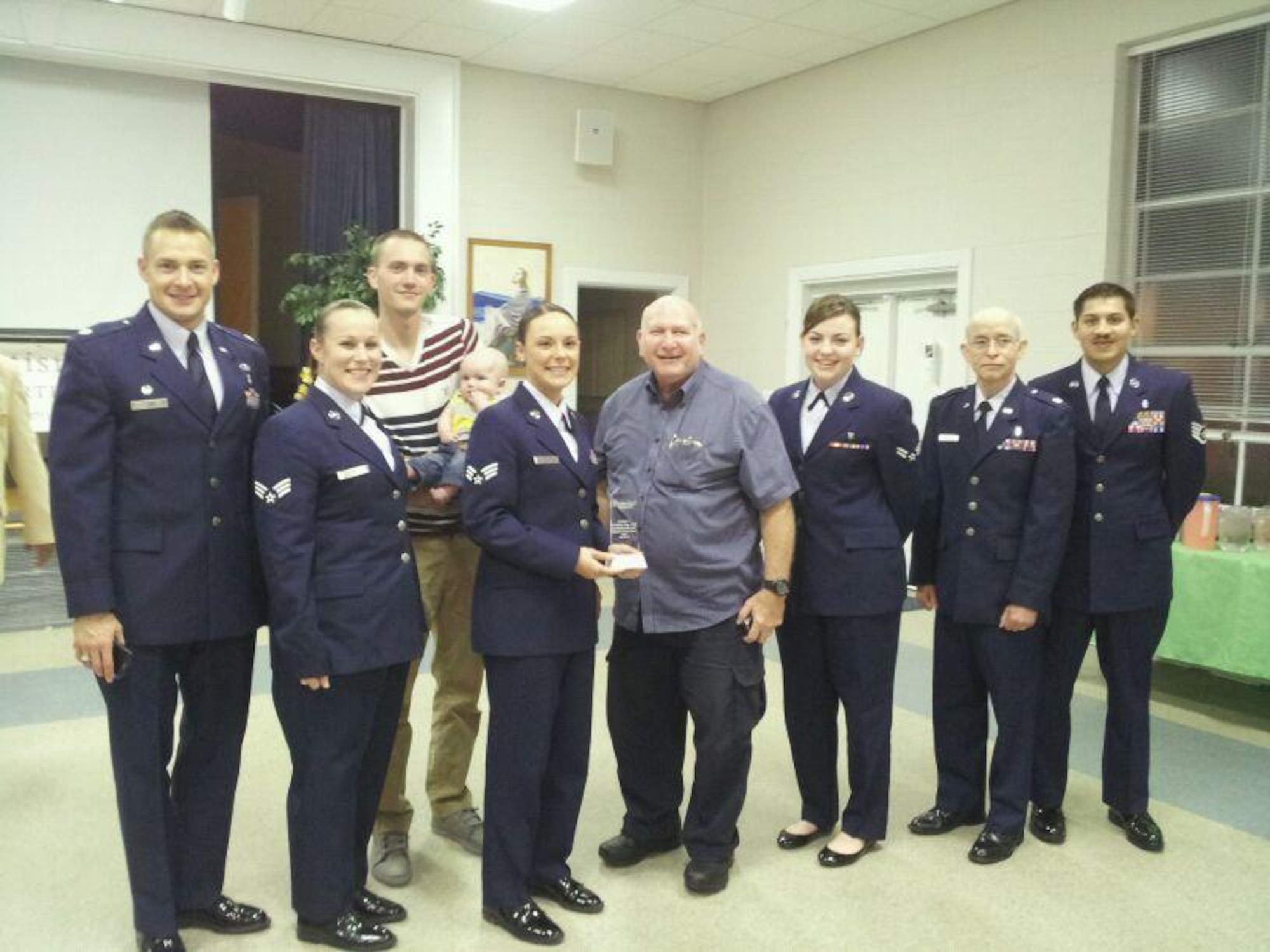 U.S. Air Force Airmen from the 4th Medical Operations Squadron Pediatric clinic show off their “Outstanding Service Award” from the Autism Society of North Carolina, Wayne County Chapter, at St. Luke United Methodist Church in Goldsboro, N.C., April 18, 2013.  The clinic and staff were recognized for the medical care and support they provide to children with autism.  (Courtesy photo/Released)