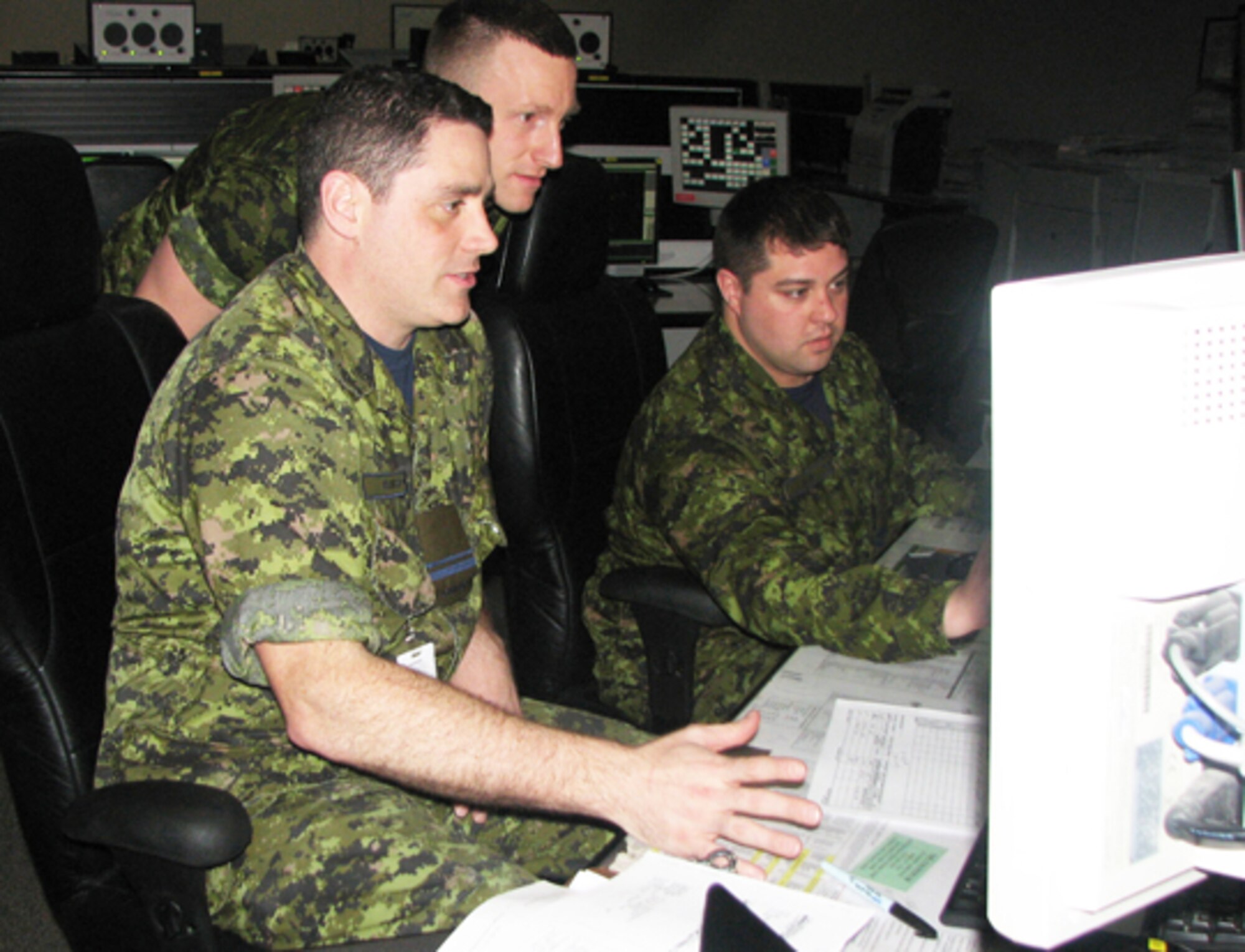 Lt. Joey Baker (left). Cpl. Adam Royer (standing) and Capt. Ben Adair of the Canadian Air Defense Sector work in the weapons section during their recent training deployment to EADS. The three were part of a group of eight Royal Canadian Air Force members from CADS that trained at EADS from March 23 through April 20.
