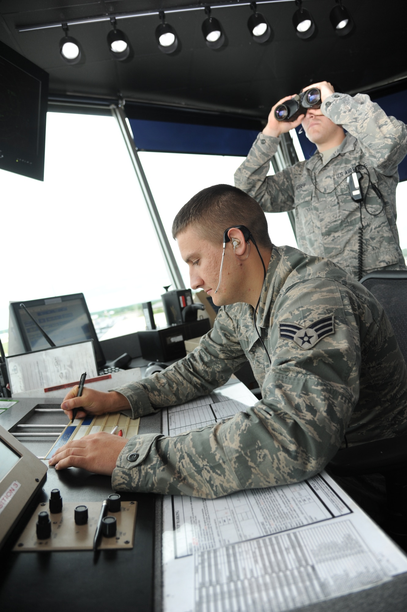 Senior Airman Cody Baker and Airman 1st Class Daryle Hesser, 81st Operations Support Flight, coordinate arriving aircraft May 3, 2013, at the air traffic control tower, Keesler Air Force Base, Miss.  Airfield Operators perform and manage airfield operations functions and activities, including air traffic control, airfield management, and base operations to facilitate the flying mission at their base. They provide staff supervision and technical assistance, as well as develop and formulate plans and policies for managing and operating Air Force airfield operations.  (U.S. Air Force photo by Kemberly Groue)